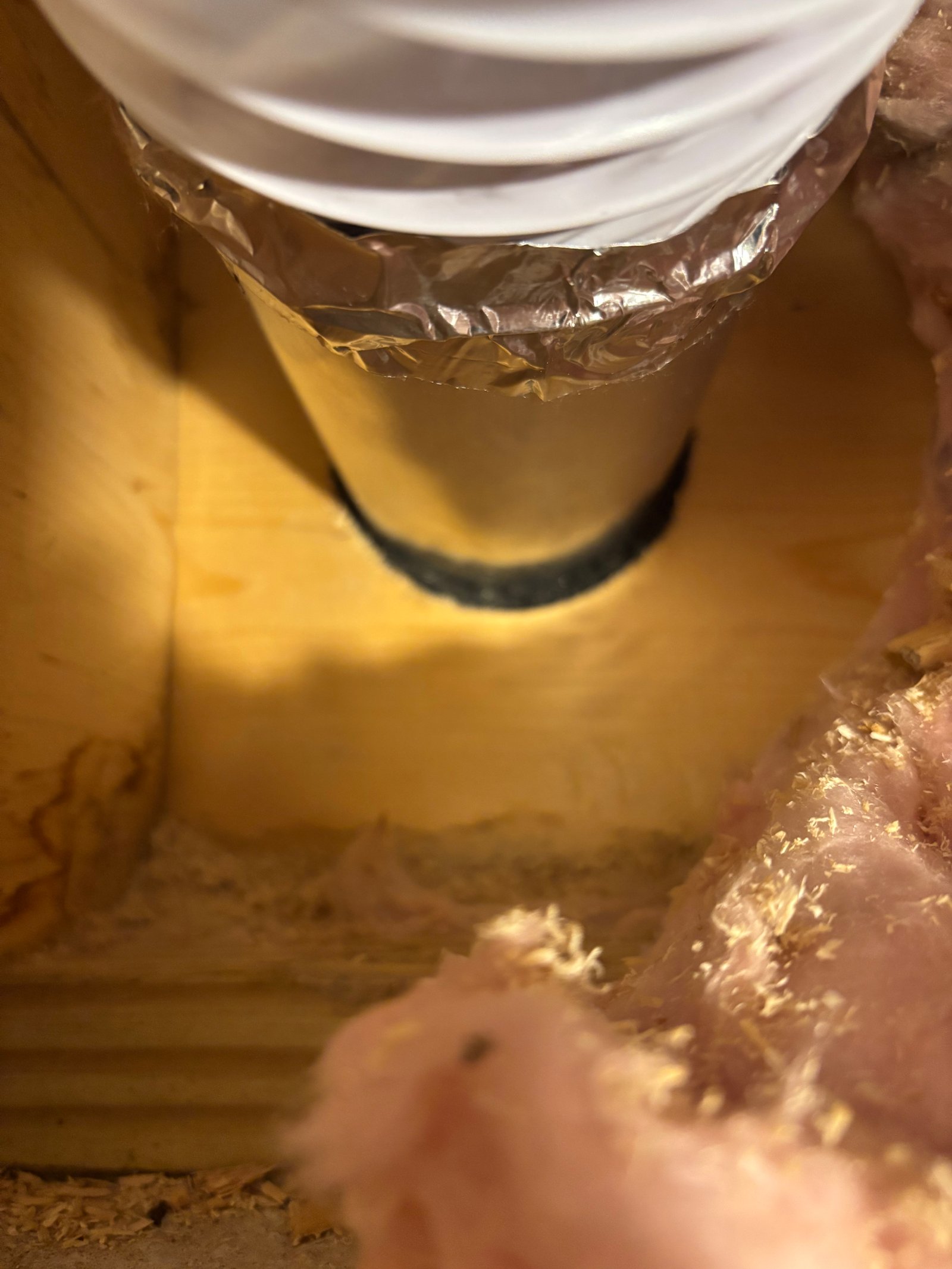 The same dryer vent after sealing — foil tape around the duct closes the gap